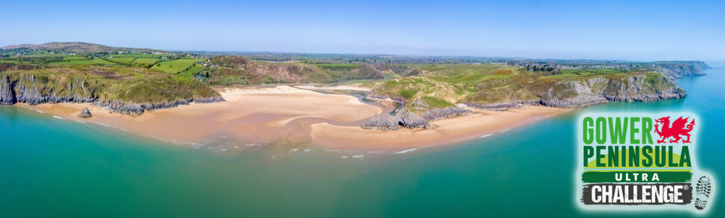 Image of Gower coastline in Wales with blue sky and Ultra Challenge logo