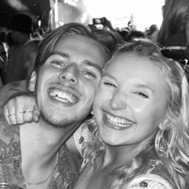 A black and white selfie of Hannah and Jack. They are both grinning from ear to ear, and Hannah's arm is thrown around Jack's shoulder.