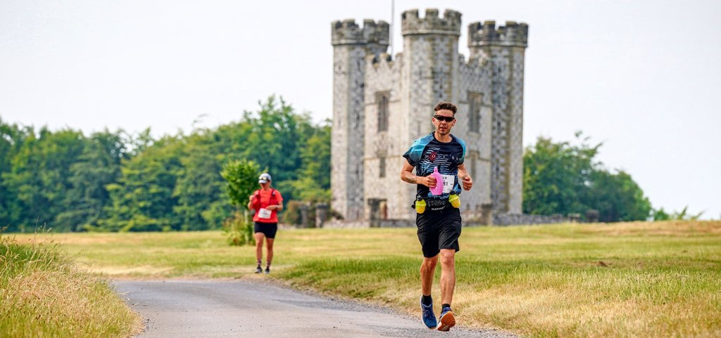 Man running with castle and fields in the background