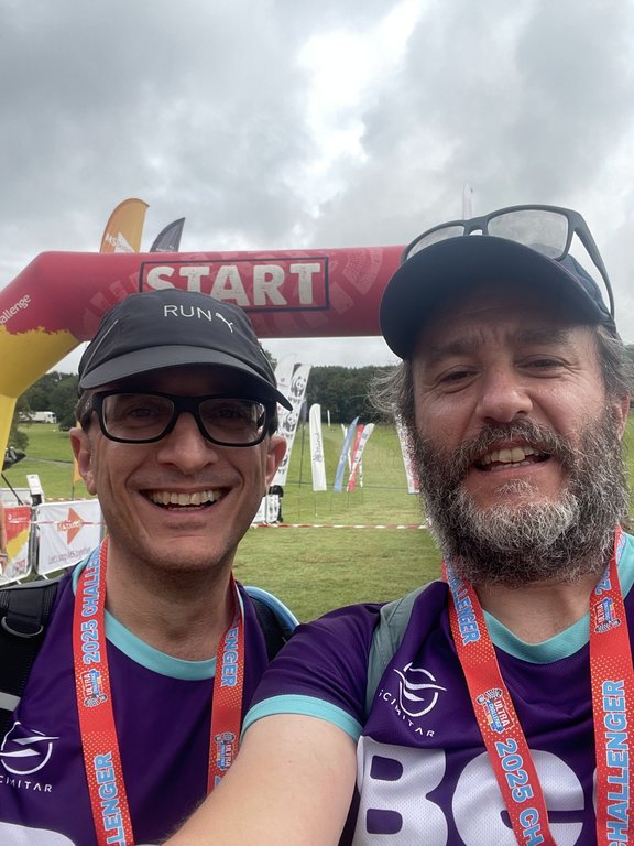 Man holding a medal and certificate wearing a purple Beat t-shirt