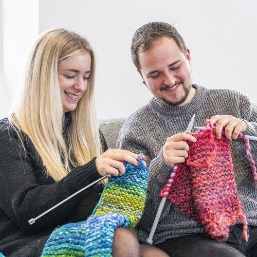 Two people knitting twogether