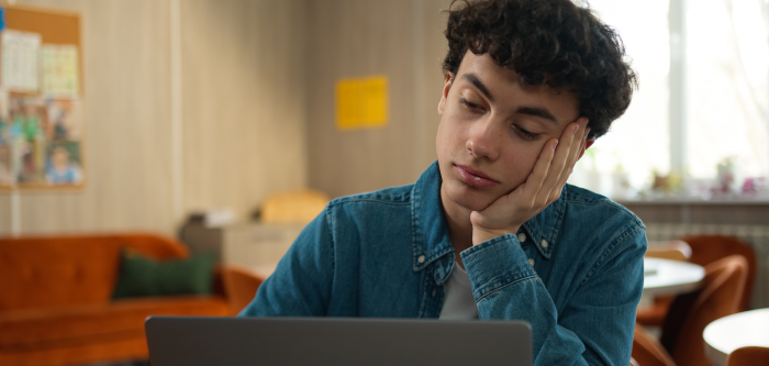 teenage boy sat in front of a laptop